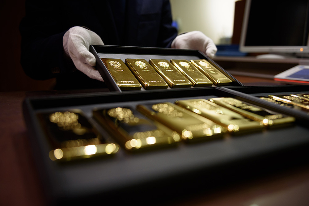 Seorang karyawan memamerkan emas batangan seberat satu kilogram untuk difoto di toko Tanaka Holdings Co. di Tokyo, Jepang. Bloomberg/Akio Kon