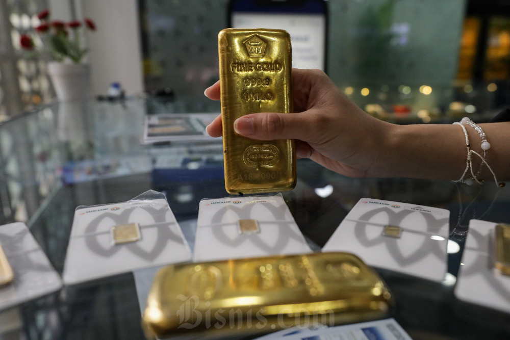 Karyawati memperlihatkan kepingan emas Antam di Jakarta, Senin (30/6/2025). Bisnis/Arief Hermawan P