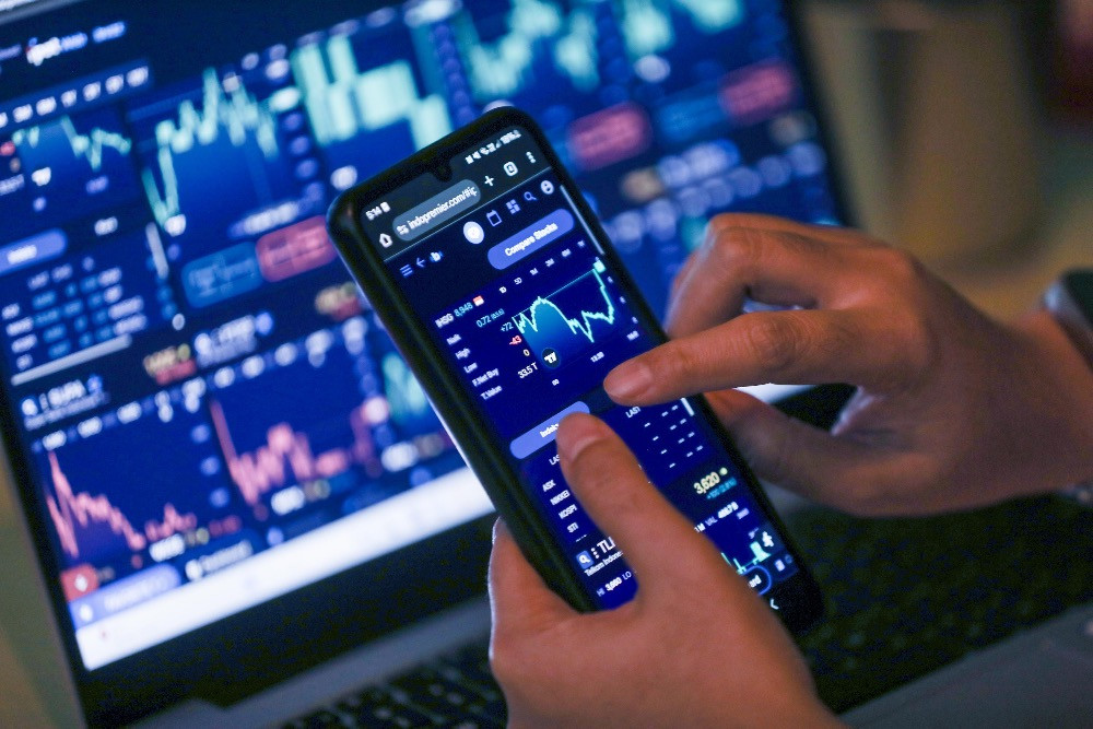 Investor mengamati pergerakan harga saham menggunakan gawai di Jakarta, Rabu (13/1/2026)./Bisnis/Himawan L. Nugraha