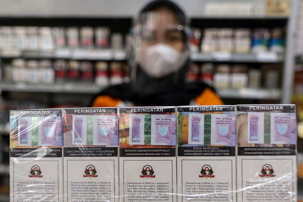Pekerja menata bungkus rokok bercukai di salah satu minimarket di Jakarta. Bisnis/Eusebio Chrysnamurti