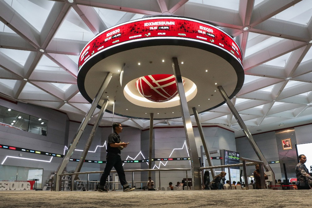 Pengunjung beraktivitas di dekat layar pergerakan saham gabungan PT Bursa Efek Indonesia (BEI) di Jakarta, Senin (28/4/2025)./ JIBI/Bisnis/Fanny Kusumawardhani