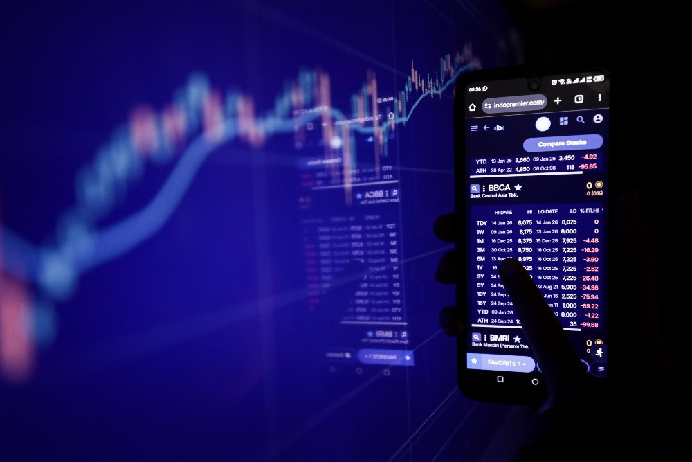 Investor mencari informasi pergerakan harga saham di Jakarta, Rabu (14/1/2026)./JIBI/Bisnis/Arief Hermawan P