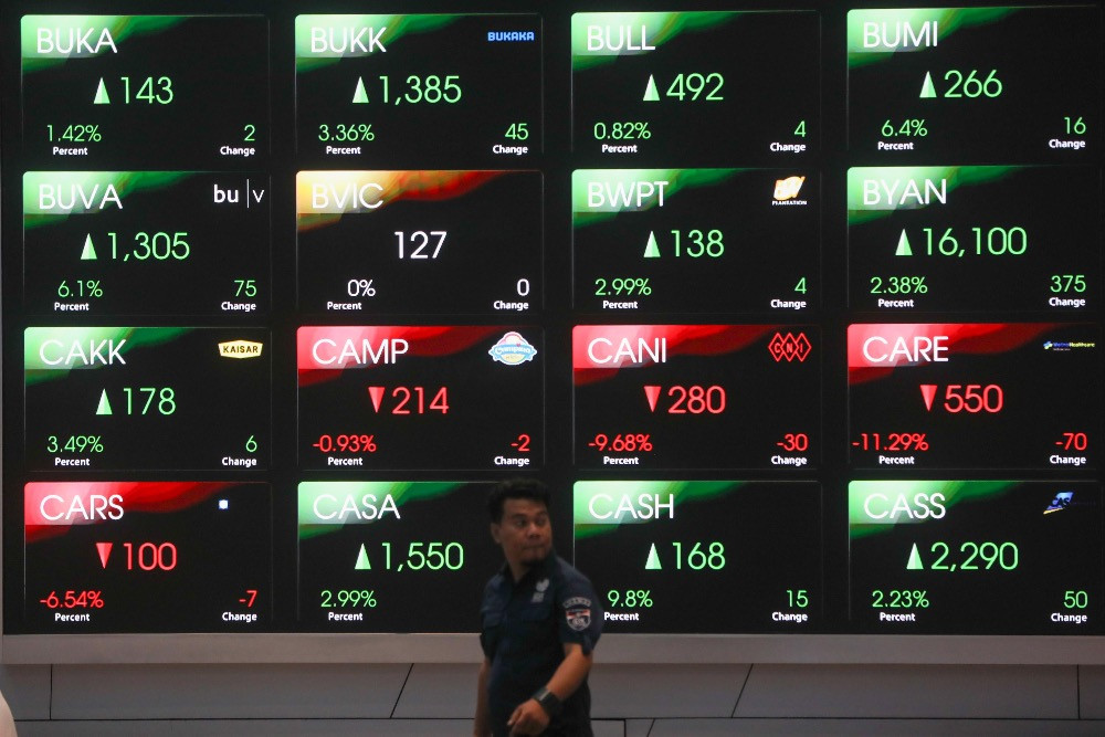 Pegawai beraktivitas di dekat layar pergerakan harga saham di galeri BEI, Jakarta, Jumat (30/1/2026)./Bisnis/Himawan L. Nugraha