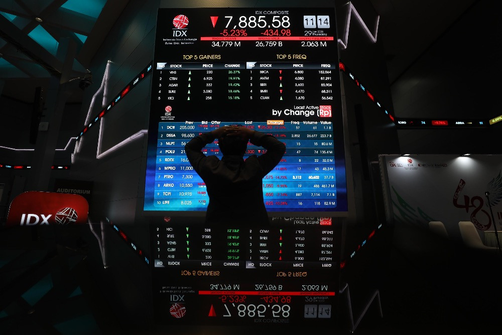 Pegawai mengamati pergerakan harga saham di galeri BEI, Jakarta, Kamis (29/1/2026)./Bisnis/Himawan L. Nugraha