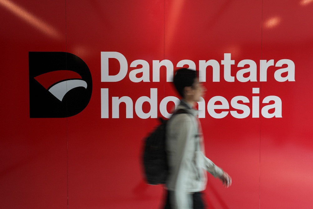 Karyawan melintas di dekat logo BPI Danantara di Jakarta, Jumat (26/9/2025)./JIBI/Bisnis/Arief Hermawan P