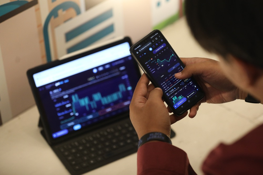 Investor mengamati harga saham menggunakan gawai di Jakarta, Selasa (3/3/2026)./Bisnis/Himawan L. Nugraha