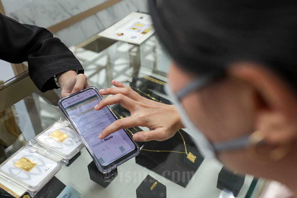 Pegawai melayani pengunjung memilih emas 24 karat di kantor Antam, Jakarta, Senin (25/7/2022). Secara fundamental, faktor geopolitik dan kondisi makroekonomi global dinilai masih mendukung pergerakan emas sebagai aset lindung nilai. /Bisnis-Himawan L Nugraha