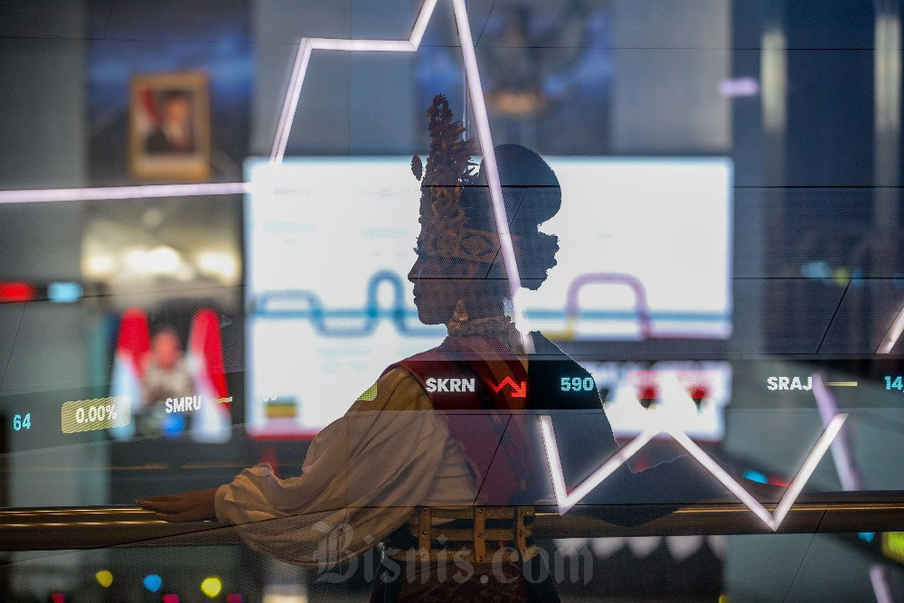 Karyawan mengamati pergerakan Indeks Harga Saham Gabungan (IHSG) di Jakarta, Senin (1/12/2025). Bisnis/Eusebio Chrysnamurti
