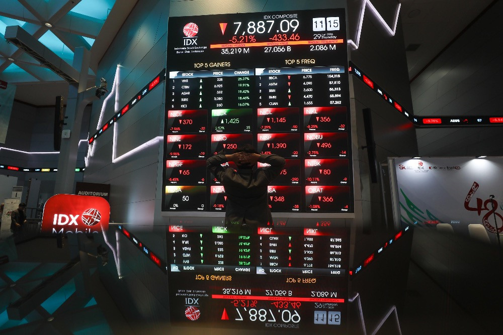 Pegawai mengamati pergerakan harga saham di galeri BEI, Jakarta, Kamis (29/1/2026)./Bisnis/Himawan L. Nugraha