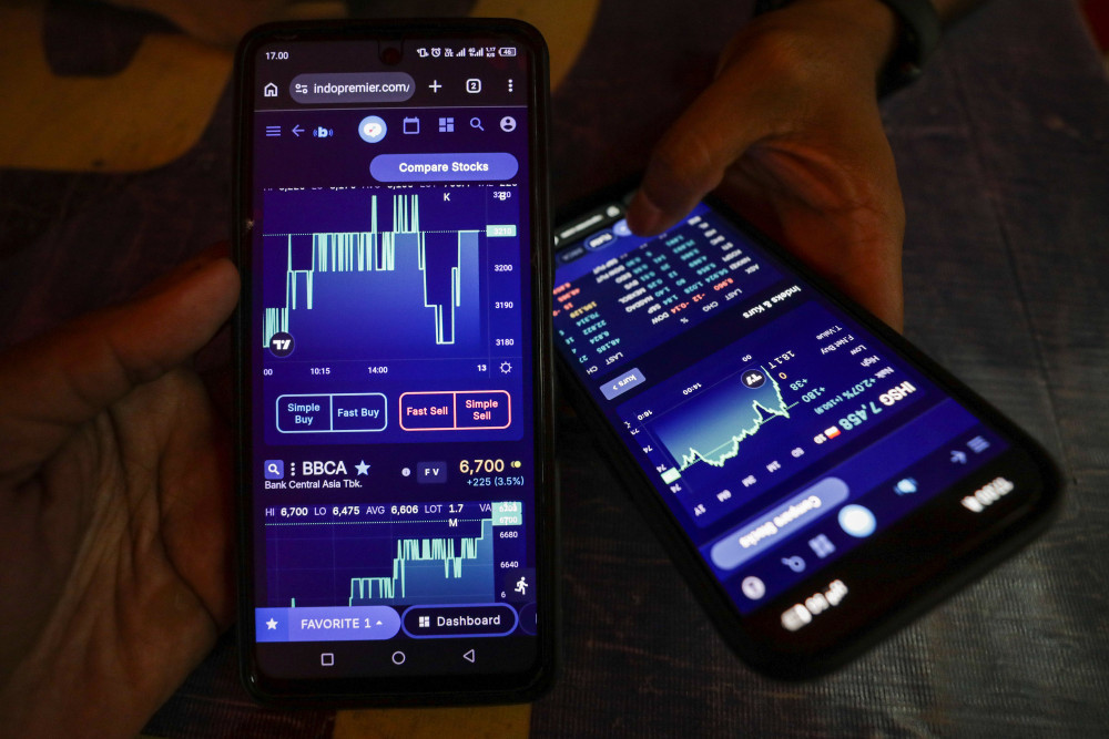 Investor mencari informasi harga saham melalui salah satu paltform digital di Jakarta, Jumat (10/4/2026). Bisnis/Arief Hermawan P