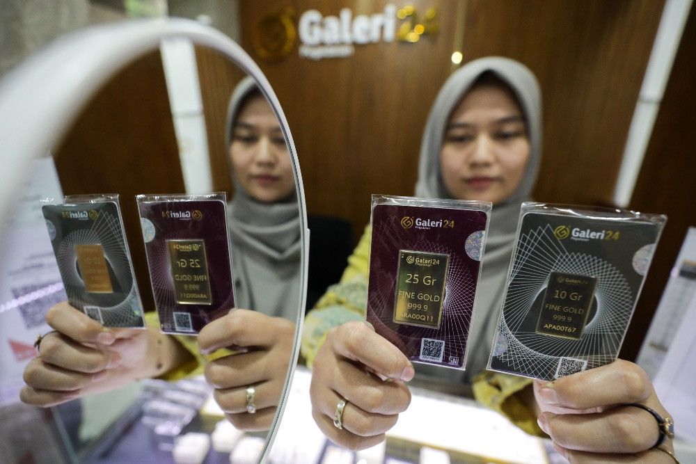Karyawati memperlihatkan logam mulia di salah satu gerai Galeri 24 di Jakarta, Senin (21/4/2025)./JIBI/Bisnis/Arief Hermawan