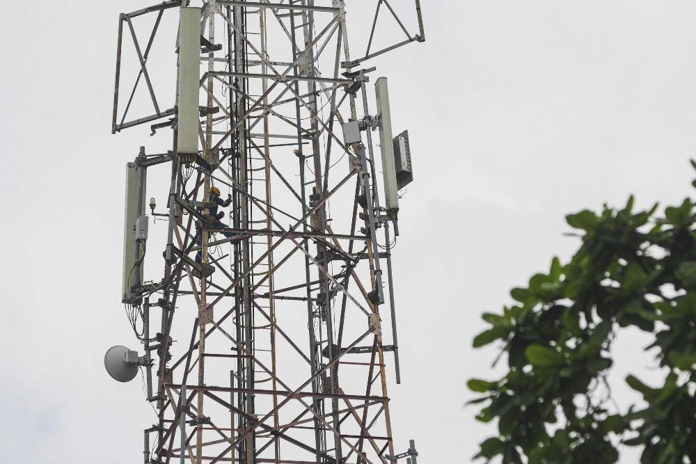 Petugas melakukan perbaikan pada salah satu menara Base Transceiver Station (BTS) di Jakarta.