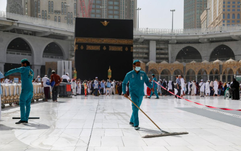 Petugas memakai masker wajah pelindung saat mereka membersihkan lantai di Masjidil Haram di kota suci Mekah, Arab Saudi, 3 Maret 2020. 