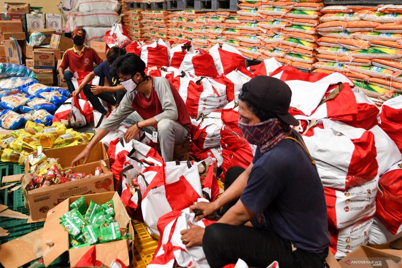 Pekerja mengemas paket bantuan sosial (bansos) di Gudang Food Station Cipinang, Jakarta,. ANTARA FOTO/M Risyal Hidayat