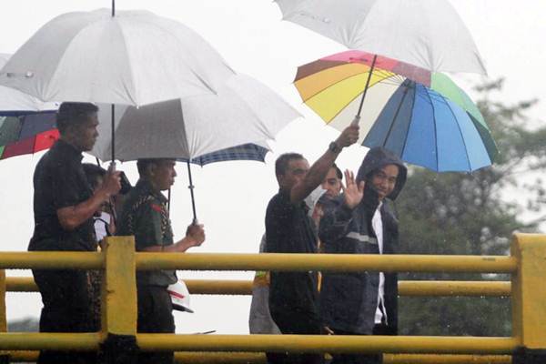 Tinjau Pembangunan Irigasi Gowa, Jokowi Kenakan Jas Hujan