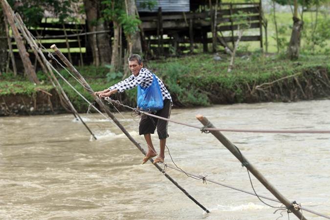 Warga Aceh Barat Seberangi Sungai Krueng Meureubo dengan Tali Kabel Listrik