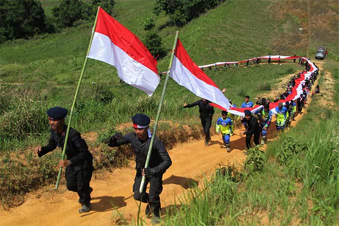 MEMBENTANGKAN BENDERA MERAH PUTIH DI PUNCAK GUNUNG