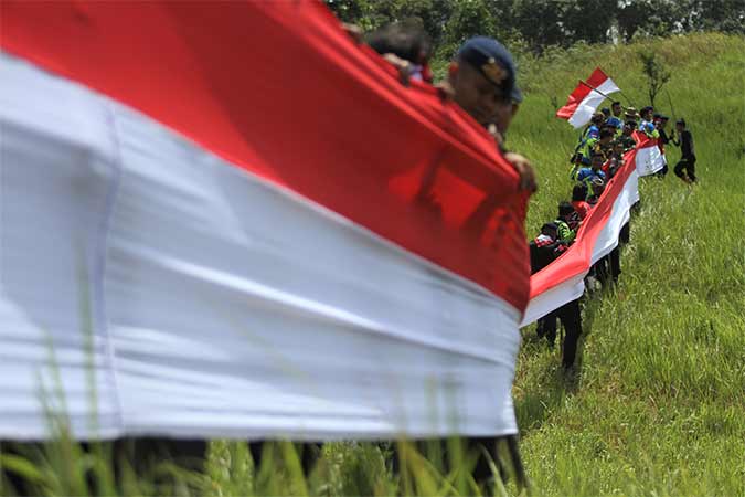 MEMBENTANGKAN BENDERA MERAH PUTIH DI PUNCAK GUNUNG