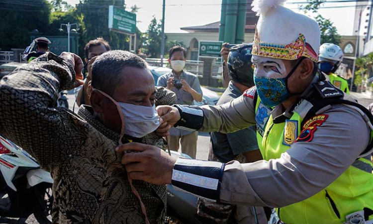 POLISI GUNAKAN KOSTUM PUNKAWAN SAAT BAGIKAN MASKER
