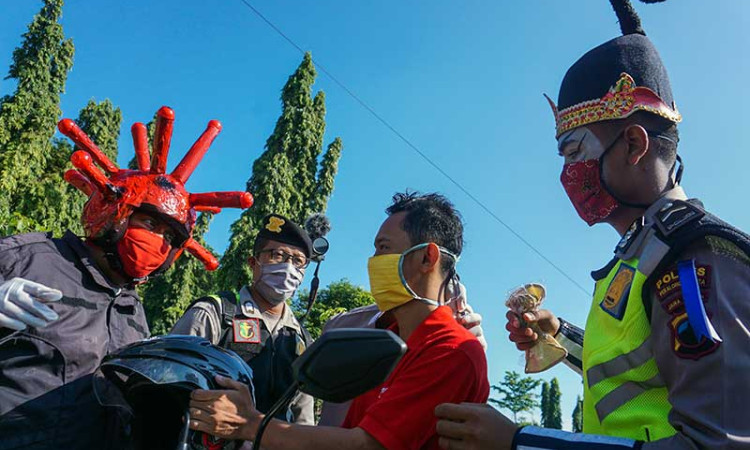 POLISI GUNAKAN KOSTUM PUNKAWAN SAAT BAGIKAN MASKER