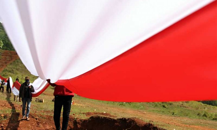 Anggota Karang Taruna Puriala Bentangkan Bendera Merah Putih Sepanjang 200 Meter
