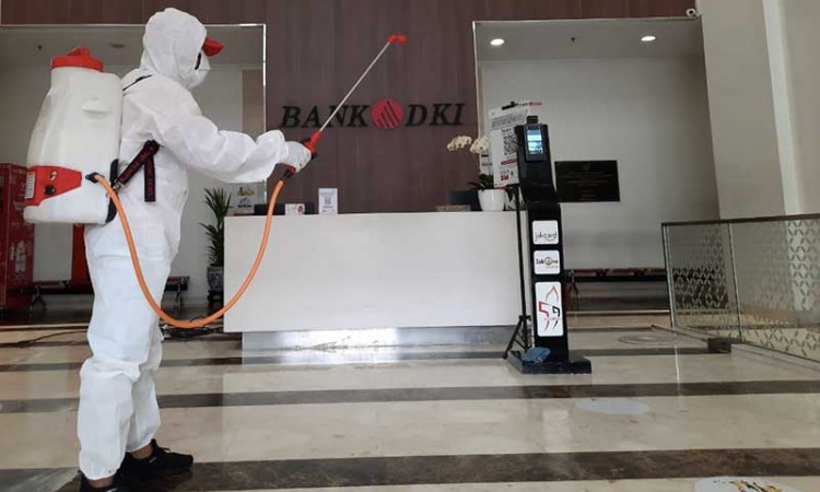 Petugas PMI Menyemprotkan Disinfektan di Kantor Pusat Bank DKI