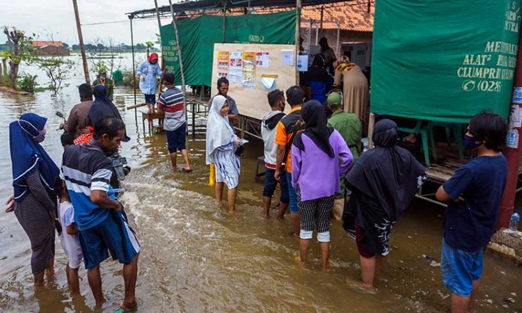 Warga Tetap Gunakan Hak Pilihnya Meski TPS Terendam Banjir