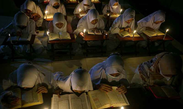 Santri di Solo Mengaji Menggunakan Penerangan Lilin 