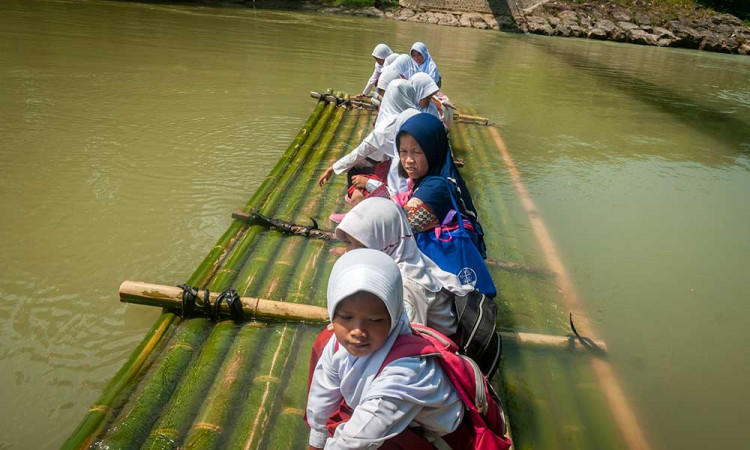 Jembatan Putus, Siswa di Banten Sebrangi Sungai Menggunakan Rakit Bambu