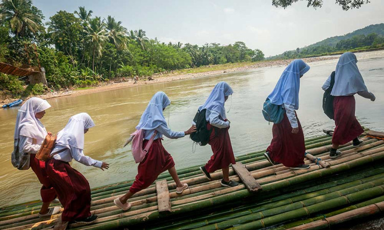 Jembatan Putus, Siswa di Banten Sebrangi Sungai Menggunakan Rakit Bambu