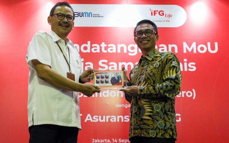 Direktur Utama IFG Life Harjanto Tanuwidjaja (kiri) bertukar cinderamata dengan Direktur Utama Pos Indonesia Faizal R. Djoemadi seusai acara penandatanganan PT Asuransi Jiwa IFG (IFG Life) dengan PT Pos Indonesia (Persero) di Jakarta, Rabu (14/9/2022). Bisnis/Suselo Jati