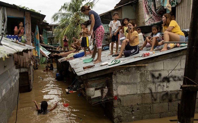 Warga berada di atap rumah mereka saat banjir akibat Topan Super Noru di San Miguel, Filipina, Seniin (26/9/2022). Banjir tersebut akibat dari badai topan Noru yang menerjang kawasan itu. REUTERS/Adrian Portugal