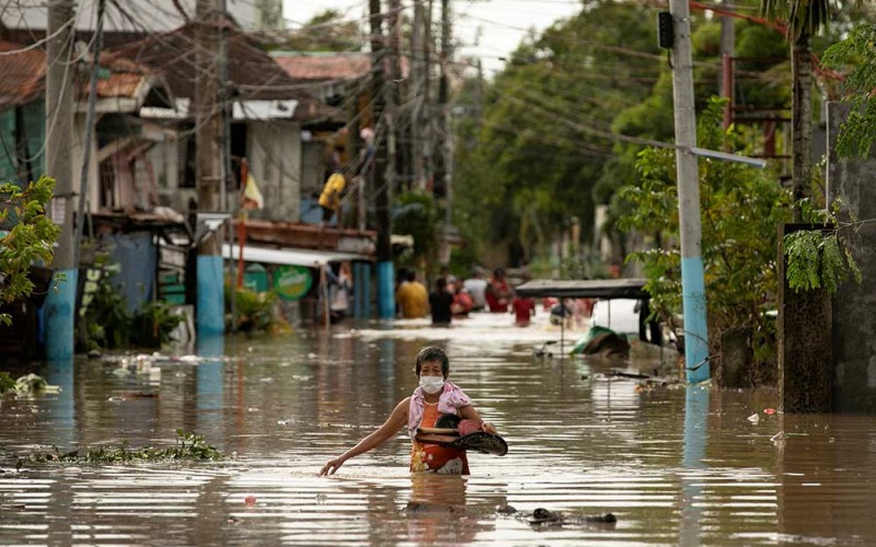 Warga melintasi banjir yang menggenangi jalanan di kota San Miguel, provinsi Bulacan, Filipina, Senin (26/9/2022). Banjir tersebut akibat dari badai topan Noru yang menerjang kawasan itu. REUTERS/Eloisa Lopez