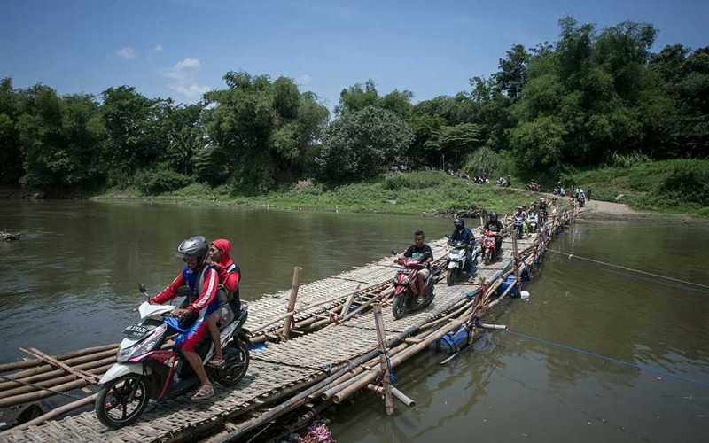 Sejumlah pengendara sepeda motor antre melintasi jembatan sesek bambu yang menghubungkan Mojolaban, Sukoharjo dengan Kampung Sewu, Solo, Jawa Tengah, Senin (26/9/2022). Sejumlah warga terpaksa memanfaatkan jembatan sesek tersebut sebagai jalan alternatif untuk menyebrangi sungai Bengawan Solo karena jembatan utama yang menghubungkan kedua wilayah itu ditutup sementara untuk proses perbaikan. ANTARA FOTO/Mohammad Ayudha