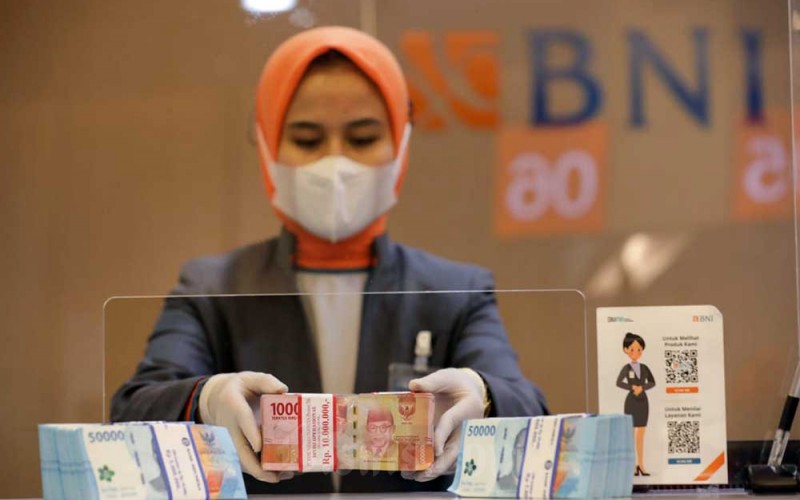Pegawai merapikan uang Rupiah di kantor cabang BNI, Jakarta, Rabu (28/9/2022). Bank Indonesia (BI) melaporkan peredaran uang kartal pada Agustus 2022 tercatat sebesar Rp805,5 triliun atau tumbuh sebesar 7,3 persen, lebih rendah dari bulan sebelumnya yang tumbuh 8,3 persen. Bisnis/Himawan L Nugraha