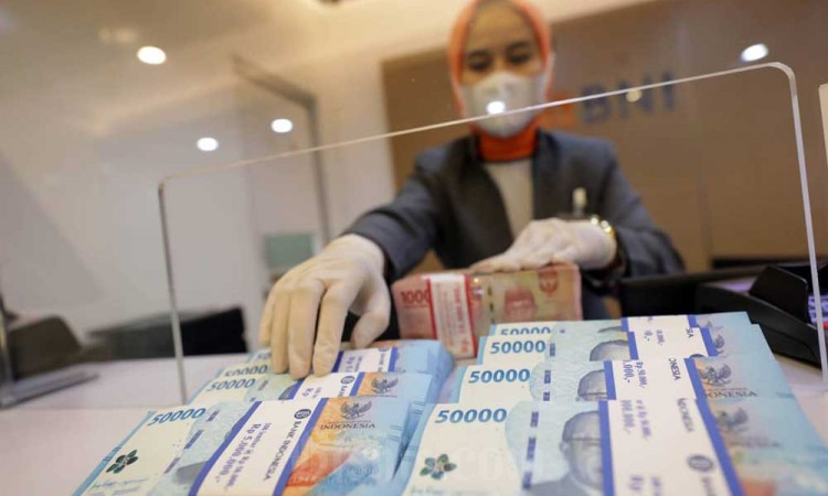 Pegawai merapikan uang Rupiah di kantor cabang BNI, Jakarta, Rabu (28/9/2022). Bank Indonesia (BI) melaporkan peredaran uang kartal pada Agustus 2022 tercatat sebesar Rp805,5 triliun atau tumbuh sebesar 7,3 persen, lebih rendah dari bulan sebelumnya yang 