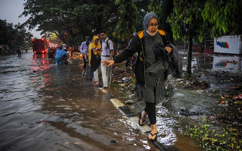 Warga menerjang air yang menggenangi Jalan Soekarno-Hatta, Gedebage, Bandung, Jawa Barat, Senin (3/10/2022). Hujan lebat yang terjadi pada Senin (3/10/2022) sore hari membuat kawasan tersebut terendam air setinggi 30 hingga 70 sentimeter akibat sistem drainase yang buruk serta menyebabkan beberapa kendaraan roda dua dan empat mogok. ANTARA FOTO/Raisan Al Farisi