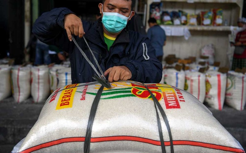 Pembeli mengikat beras yang dibeli di Pasar Induk Beras Cipinang, Jakarta, Senin (3/10/2022). Sistem Pemantauan Pasar dan Kebutuhan Pokok Kementerian Perdagangan (Kemendag) mencatat, harga beras dalam sebulan terakhir naik sekitar satu persen per 30 September 2022 lalu pada beras premium menjadi Rp12.700 per kilogram dan beras medium di harga Rp10.700 per kilogramnya dibandingkan harga pada per 1 September 2022 yang tercatat Rp12.600 per kilogram untuk beras premium dan Rp10.500 per kilogram beras medium. ANTARA FOTO/M Risyal Hidayat