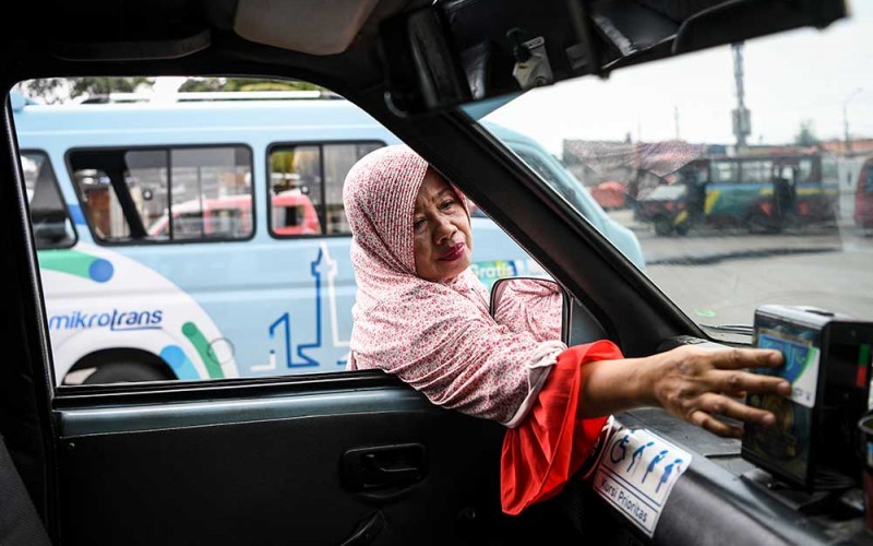 Seorang penumpang melakukan pembayaran menggunakan kartu Jaklingko saat akan menaiki angkutan kota Mikrotrans di Terminal Pulo Gadung, Jakarta, Selasa (4/10/2022). Pemerintah Provinsi DKI Jakarta menargetkan sebanyak 10.047 angkutan perkotaan (angkot) di Jakarta sudah terintegrasi dengan sistem pembayaran antarmoda JakLingko pada tahun 2030. ANTARA FOTO/M Risyal Hidayat