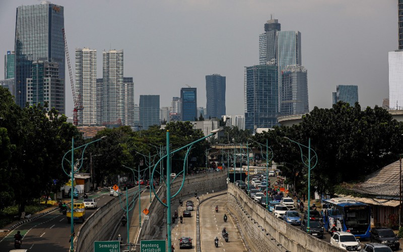 Kendaraan melintas dengan latar jajaran gedung bertingkat di Jakarta, Minggu (27/11/2022). Gubernur Bank Indonesia Perry Warjiyo menyampaikan, BI sangat berhati-hati dalam menyusun asumsi makro ekonomi pada 2023 dikarenakan gejolak dan ketidakpastian global yang sangat tinggi. Bank Indonesia (BI) memperkirakan pertumbuhan ekonomi Indonesia akan mencapai 4,37 persen pada tahun depan atau 2023. Bisnis/Abdurachman 