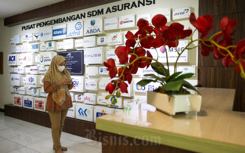 Karyawati beraktivitas di dekat logo-logo asuransi umum di kantor Asosiasi Asuransi Umum Indonesia (AAUI) di Jakarta, Rabu (30/11/2022). AAUI menyampaikan asuransi umum mengalami pertumbuhan hingga kuartal III/2022 sebesar 6,8 persen menjadi Rp195,8 triliun. Pada periode yang sama 2021, kinerja asuransi umum mencapai Rp183,2 triliun. Bisnis/Suselo Jati