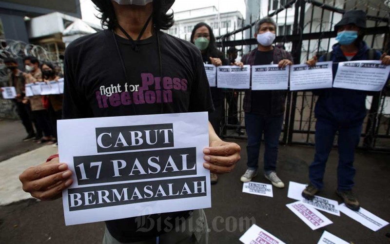 Jurnalis yang tergabung dalam Aliansi Jurnalis Independen (AJI) Bandung melakukan Aksi Tolak RKUHP di depan Gedung DPRD Provinsi Jawa Barat, Bandung, Jawa Barat, Senin (5/12/2022). Aksi yang digelar serentak AJI Kota lainnya di Tanah Air ini menuntut Pemerintah dan DPR untuk mencabut 17 pasal bermasalah dalam Rancangan Kitab Undang-undang Hukum Pidana (RKUHP) yang dinilai berpotensi mengekang kerja jurnalistik dan mengkriminalisasi jurnalis. Untuk menyuarakan penolakan tersebut, AJI Bandung menggelar aksi diam selama 17 menit, melambangkan 17 pasal bermasalah. Bisnis/Rachman