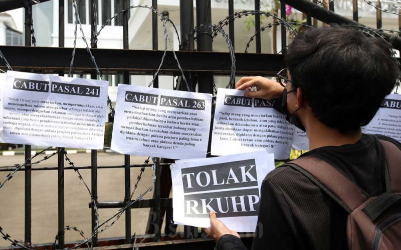 Jurnalis yang tergabung dalam Aliansi Jurnalis Independen (AJI) Bandung melakukan Aksi Tolak RKUHP di depan Gedung DPRD Provinsi Jawa Barat, Bandung, Jawa Barat, Senin (5/12/2022). Aksi yang digelar serentak AJI Kota lainnya di Tanah Air ini menuntut Pemerintah dan DPR untuk mencabut 17 pasal bermasalah dalam Rancangan Kitab Undang-undang Hukum Pidana (RKUHP) yang dinilai berpotensi mengekang kerja jurnalistik dan mengkriminalisasi jurnalis. Untuk menyuarakan penolakan tersebut, AJI Bandung menggelar aksi diam selama 17 menit, melambangkan 17 pasal bermasalah. Bisnis/Rachman