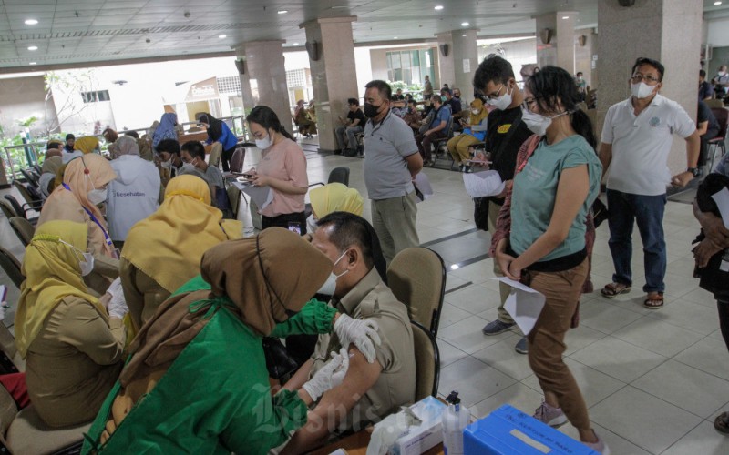 Tenaga kesehatan menyuntikkan dosis vaksin booster kedua Covid-19 kepada warga di Kantor Walikota Jakarta Selatan, Jakarta, Selasa (24/1/2023). Dinas Kesehatan DKI Jakarta mulai hari ini (24/1) secara serentak menggelar vaksinasi dosis keempat atau booster kedua bagi masyarakat umum yang berusia 18 tahun ke atas di sejumlah titik di wilayah DKI Jakarta. Bisnis/Fanny Kusumawardhani
