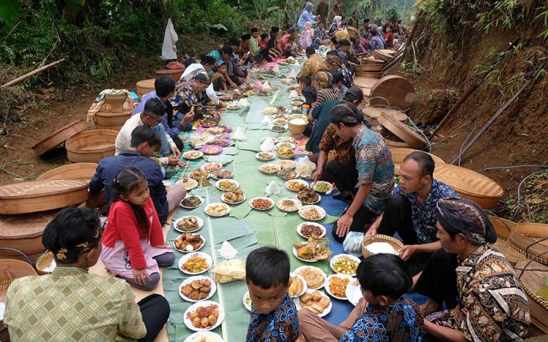 Sejumlah warga menyantap makanan bersama saat tradisi Nyadran Perdamaian di Krecek, Getas, Kaloran, Temanggung, Jateng, Jumat (27/1/2023). Tradisi Nyadran atau Merti Dusun yang dilaksanakan oleh warga lintas agama tersebut telah berlangsung sejak puluhan tahun silam yang bertujuan untuk mendoakan arwah leluhur sekaligus sebagai wujud kerukunan antar pemeluk agama. ANTARA FOTO/Anis Efizudin
