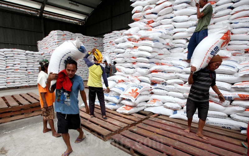 Buruh melakukan bongkar muat karung berisi beras di Gudang Bulog Divre Jawa Barat di Gedebage, Bandung, Jawa Barat, Senin (30/1/2023). Bisnis/Rachman