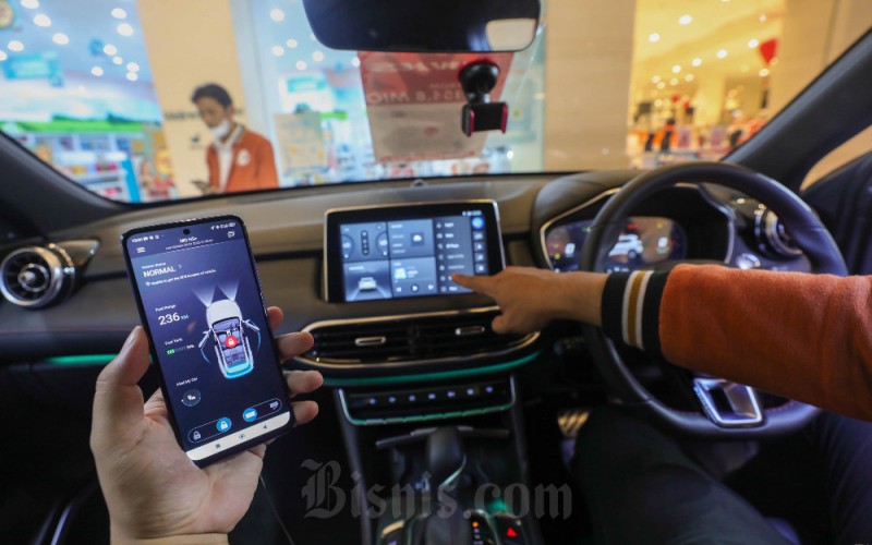 Pegawai menggunakan aplikasi ponsel untuk mobil New MG HS dalam pameran MG Motor Indonesia di Gandaria City Mall, Jakarta, Rabu (1/2/2023). MG Motor Indonesia menggelar promo khusus dimana pelanggan akan mendapatkan gratis kaca film V-Kool dan voucher bahan bakar  untuk pembelian mobil New MG HS. Promo ini juga menyertakan program aftersales berupa gratis service 4 tahun atau 50.000 kilometer (km) dan garansi 5 tahun tanpa batasan km untuk ketiga model mobil yakni, MG 5GT, New MG ZS dan New MG HS. Bisnis/Himawan L Nugraha