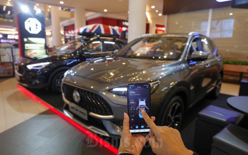 Pegawai menggunakan aplikasi ponsel untuk mobil New MG HS dalam pameran MG Motor Indonesia di Gandaria City Mall, Jakarta, Rabu (1/2/2023). MG Motor Indonesia menggelar promo khusus dimana pelanggan akan mendapatkan gratis kaca film V-Kool dan voucher bahan bakar  untuk pembelian mobil New MG HS. Promo ini juga menyertakan program aftersales berupa gratis service 4 tahun atau 50.000 kilometer (km) dan garansi 5 tahun tanpa batasan km untuk ketiga model mobil yakni, MG 5GT, New MG ZS dan New MG HS. Bisnis/Himawan L Nugraha