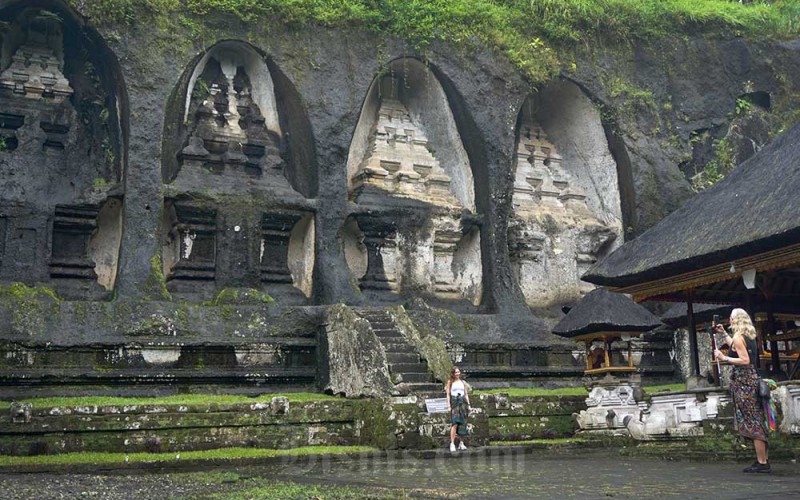 Wisatawan mancanegara berfoto di Candi Gunung Kawi, Tampaksiring, Gianyar, Bali, Minggu (5/2/2023). Objek wisata cagar budaya tersebut memiliki candi yang terpahat pada tebing batu dan dikelilingi panorama alam yang indah. ANTARA FOTO/Adiwinata Solihin