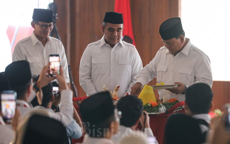 Ketua Umum Partai Gerindra Prabowo Subianto (kanan) disaksikan Wakil Ketua Dewan Pembina Sandiaga Uno (kiri) dan Sekretatis Jenderal Ahmad Muzani memotong tumpeng saat peringatan Hari Ulang Tahun (HUT) ke-15 Partai Gerindra di Jakarta, Senin (6/2/2023). Partai Gerindra menyelenggarakan peringatan HUT ke-15 yang diisi dengan rangkaian kegiatan sosial antara lain penyerahan santunan kepada anak yatim, layanan periksa kesehatan gratis, hingga donor darah. Pada kesempatan ini juga dilakukan konsolidasi internal guna memperkuat partai. Bisnis/Arief Hermawan P